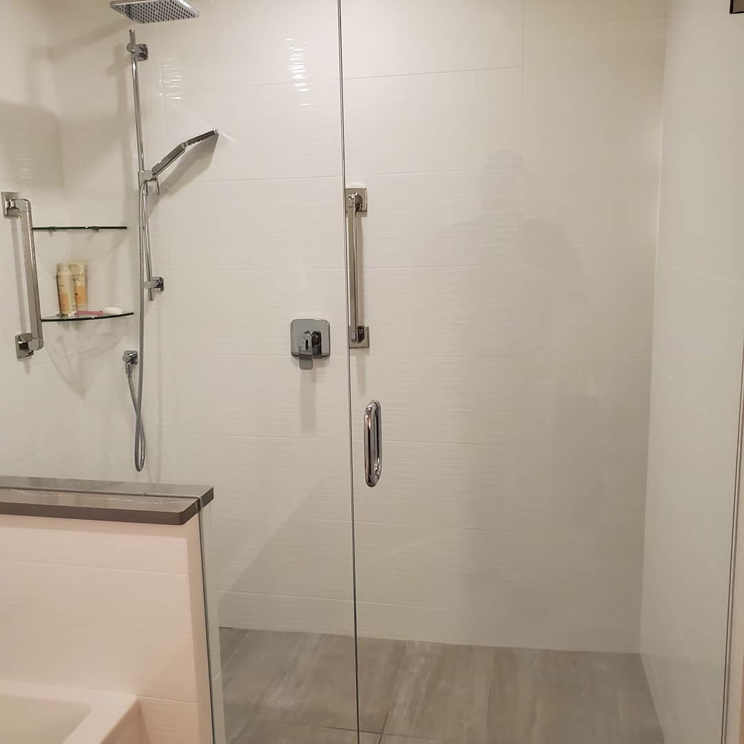 Walk-in shower with linear white tile and a plank tile floor